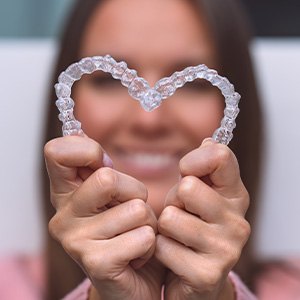 Woman holding Invisalign in the shape of a heart