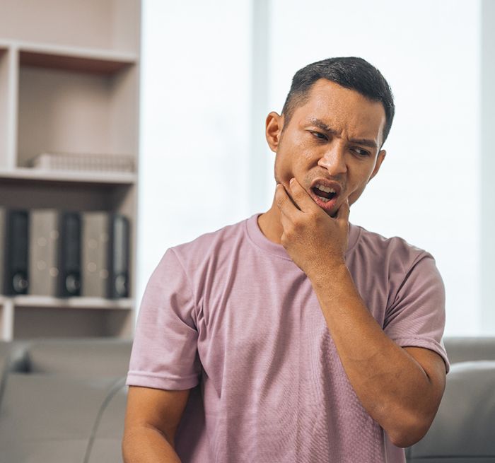 a man holding his jaw in pain