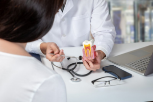 Dentist explaining a root canal treatment to patient using a model